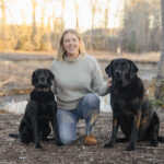 Dr. Annand outside with two black labs